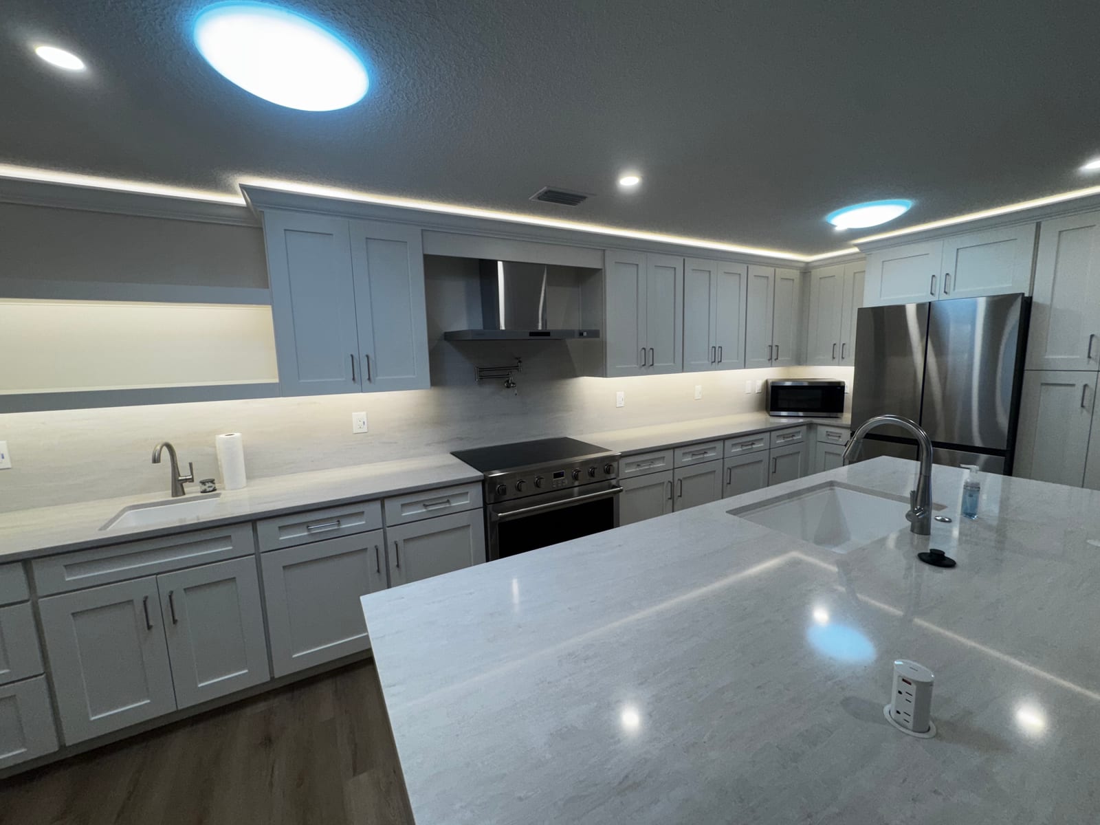 Finished kitchen remodel with quartz island and gray cabinets