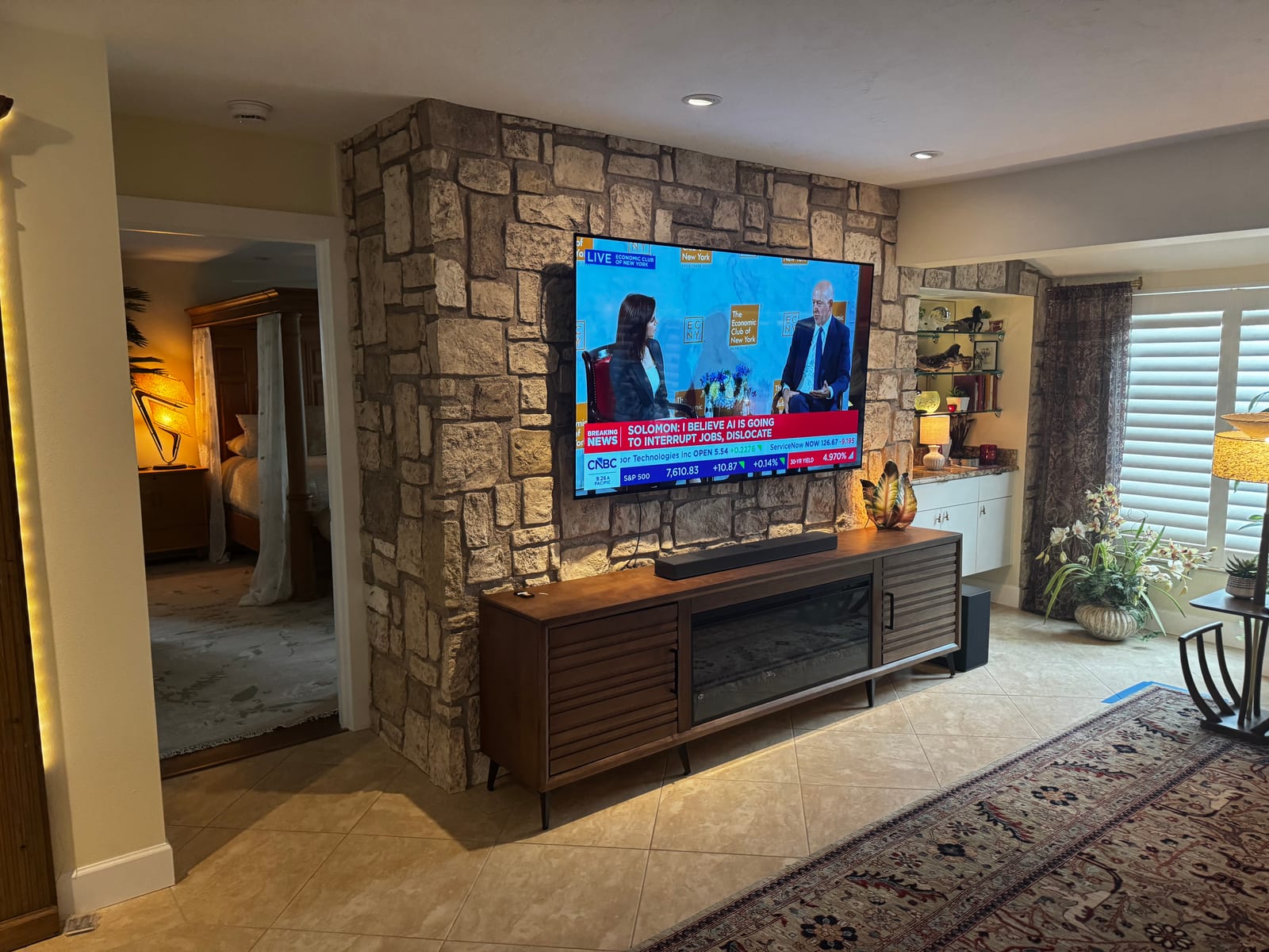 Stone media wall with mounted TV and fireplace console
